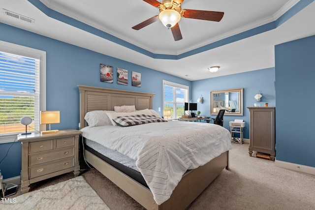 bedroom with carpet flooring, baseboards, visible vents, a raised ceiling, and crown molding