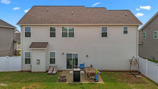 rear view of house featuring a lawn, a patio, and a fenced backyard
