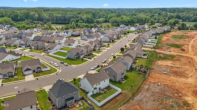 drone / aerial view featuring a wooded view and a residential view