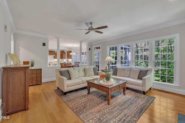 living room featuring crown molding, ceiling fan, visible vents, and light wood-style floors