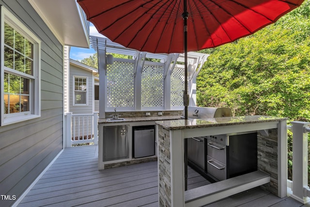 wooden terrace with a sink and area for grilling