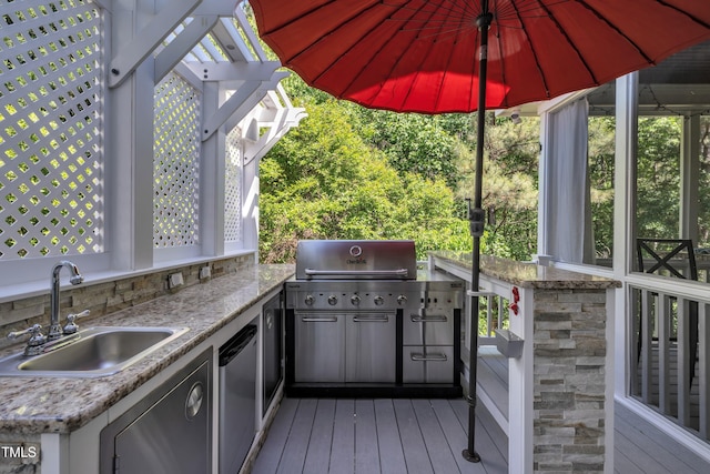 deck featuring a sink, a grill, and exterior kitchen