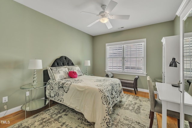 bedroom with baseboards, wood finished floors, and visible vents