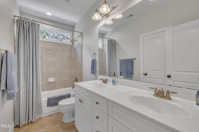 bathroom featuring toilet, visible vents, shower / bath combination with curtain, and a sink