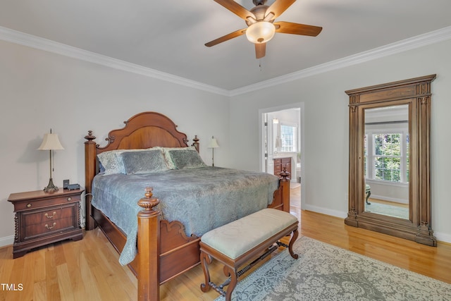 bedroom with crown molding, baseboards, ensuite bathroom, ceiling fan, and light wood finished floors