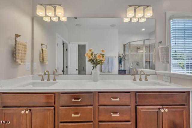 bathroom featuring a sink, a stall shower, and double vanity