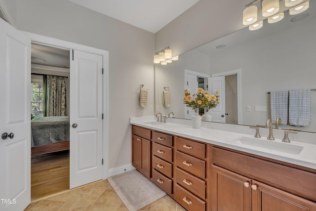 ensuite bathroom featuring ensuite bathroom, a sink, tile patterned floors, and double vanity