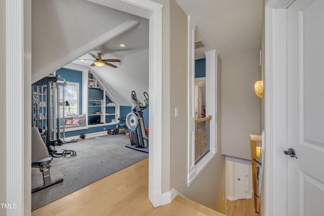 additional living space featuring visible vents, a ceiling fan, baseboards, wood finished floors, and vaulted ceiling