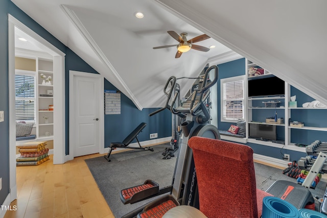 workout area with wood finished floors, lofted ceiling, baseboards, ceiling fan, and built in shelves