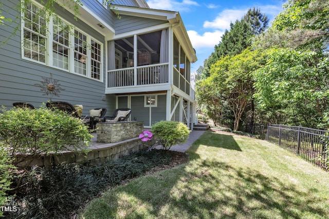 rear view of house featuring a yard, fence, a patio area, and a sunroom