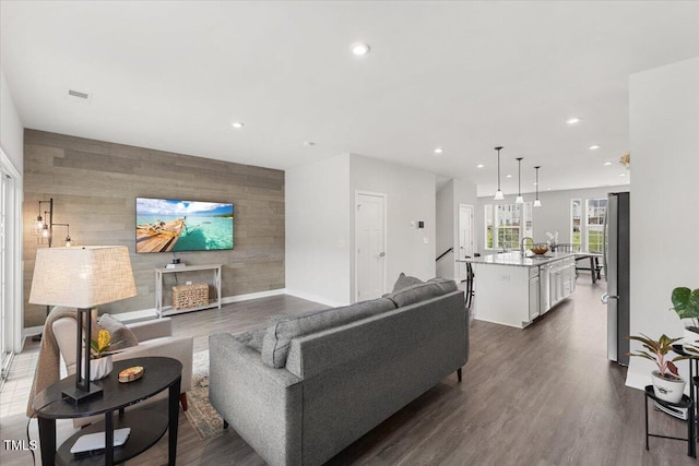 260 Amber Acorn Ave, Raleigh, NC 27603 - living area with an accent wall, recessed lighting, wooden walls, baseboards, and dark wood-style flooring