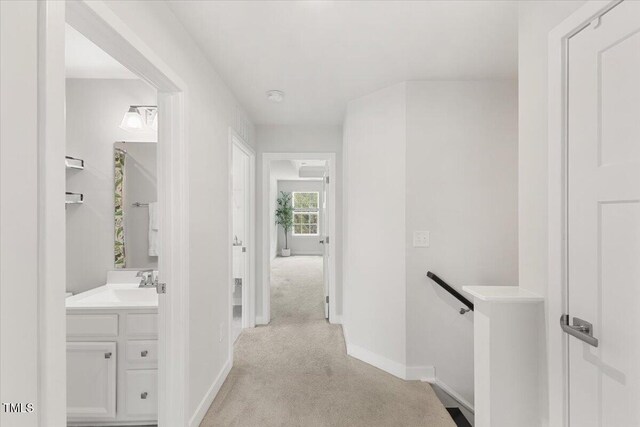 260 Amber Acorn Ave, Raleigh, NC 27603 - hallway featuring an upstairs landing, baseboards, light colored carpet, and a sink