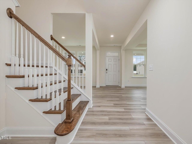 foyer entrance featuring baseboards, light wood-style flooring, recessed lighting, and stairs