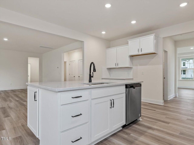kitchen featuring a kitchen island with sink, a sink, light wood-style flooring, baseboards, and dishwasher
