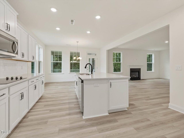kitchen with stainless steel appliances, recessed lighting, light wood-style flooring, and baseboards