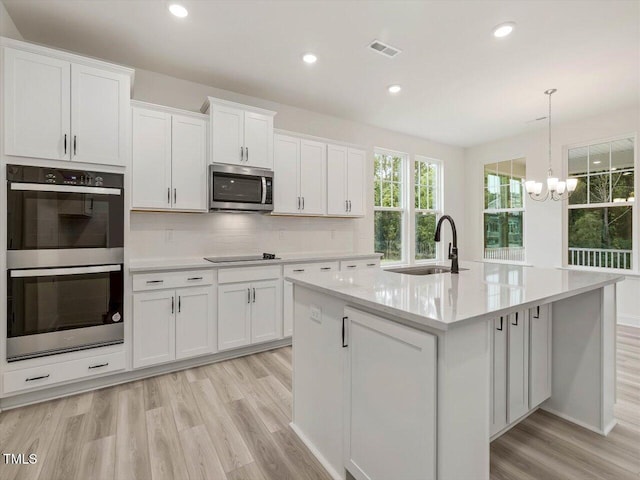 kitchen featuring a sink, a chandelier, visible vents, white cabinetry, and appliances with stainless steel finishes