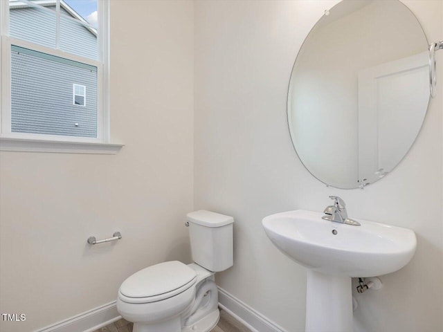 half bath with toilet and baseboards