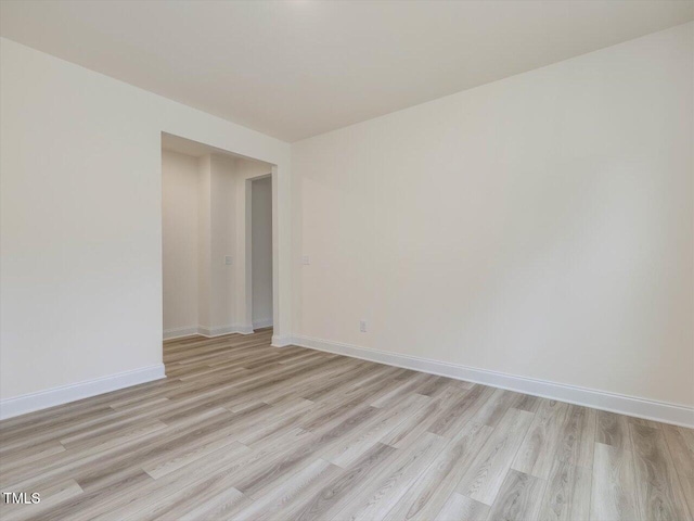 spare room featuring light wood finished floors and baseboards