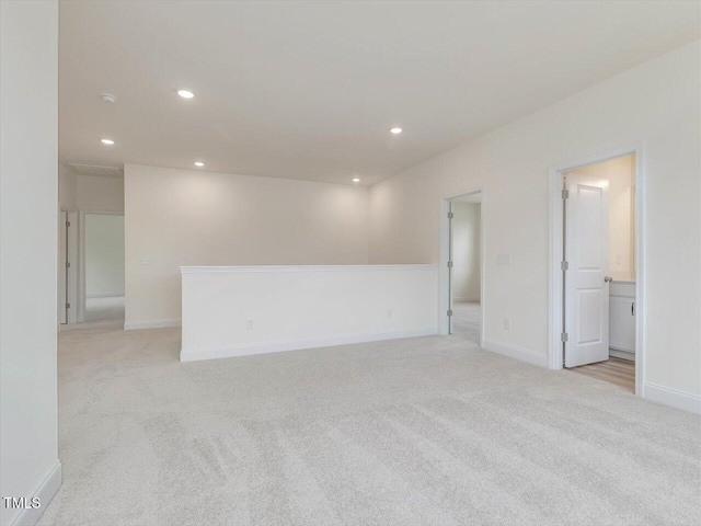spare room with recessed lighting, light colored carpet, and baseboards