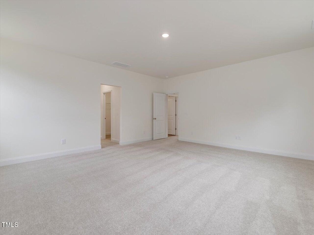 empty room with baseboards, visible vents, light carpet, and recessed lighting