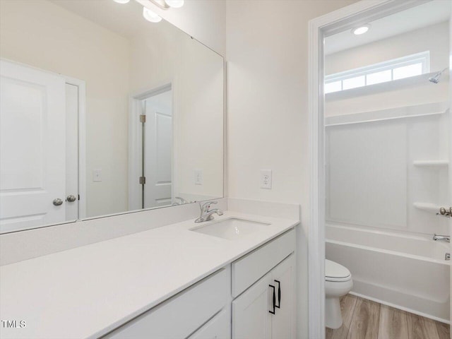 full bath with wood finished floors, toilet, and vanity