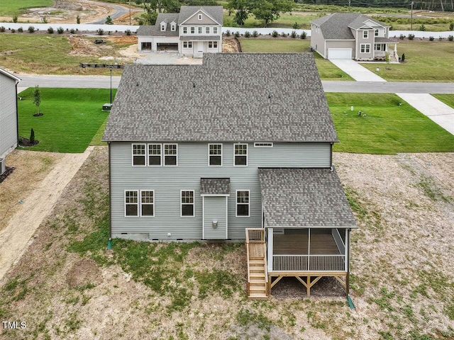 exterior space with a shingled roof, a yard, and crawl space