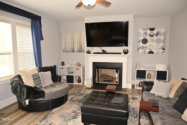 474 Ashpole Trl, Clayton, NC 27520 - living room featuring wood finished floors, ceiling fan, a fireplace with flush hearth, and baseboards