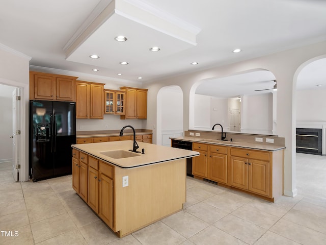 kitchen featuring arched walkways, ornamental molding, a sink, and black appliances