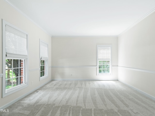 spare room featuring crown molding, carpet floors, baseboards, and visible vents