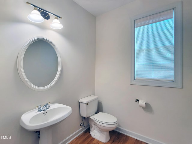 bathroom featuring a sink, baseboards, toilet, and wood finished floors