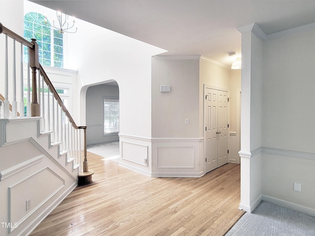 interior space featuring plenty of natural light, arched walkways, and light wood-style flooring