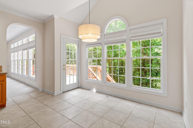 interior space with visible vents, crown molding, baseboards, arched walkways, and light tile patterned floors