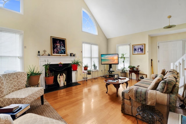 17 Nicklaus Way, Clayton, NC 27520 - living room featuring a fireplace with raised hearth, high vaulted ceiling, a wealth of natural light, and wood finished floors