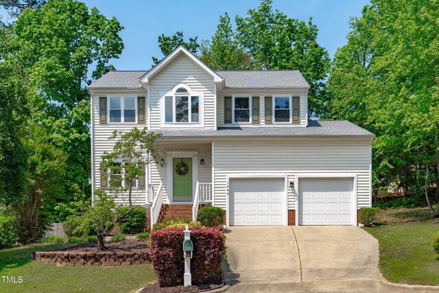 traditional-style home with an attached garage, driveway, and a front yard