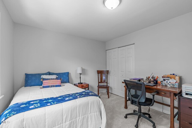 carpeted bedroom featuring a closet and baseboards