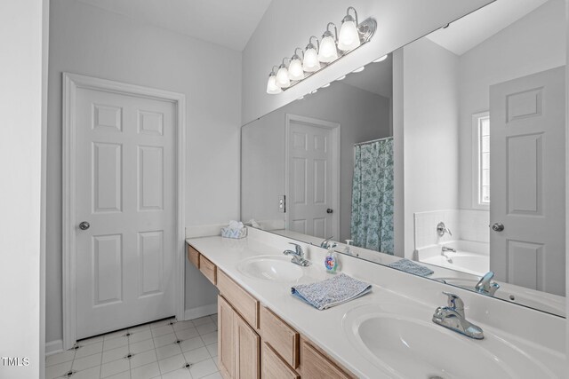 bathroom with double vanity, a sink, and a bath