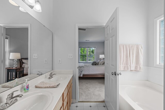 bathroom featuring connected bathroom, tile patterned floors, a sink, and a bath