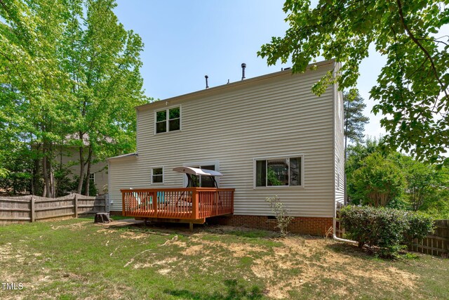 rear view of property featuring a fenced backyard, a wooden deck, a yard, and crawl space