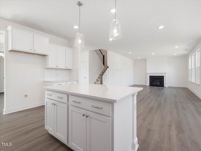 33 Celtic Ln, Lillington, NC 27546 - kitchen featuring white cabinetry, baseboards, light wood-style floors, and a kitchen island