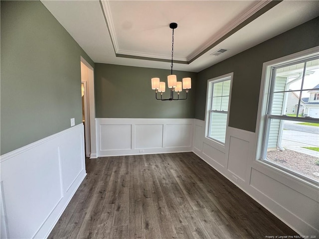 374 Whitestone Dr, Fayetteville, NC 28312 - unfurnished dining area featuring a tray ceiling, dark wood-type flooring, a chandelier, wainscoting, and a decorative wall