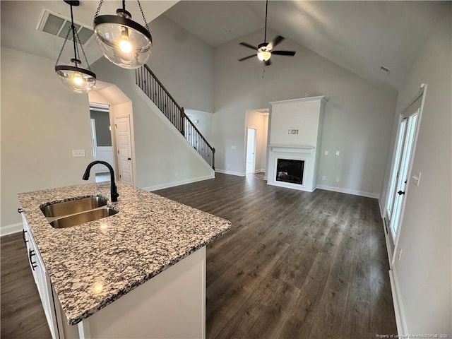 374 Whitestone Dr, Fayetteville, NC 28312 - kitchen featuring dark wood-style flooring, a center island with sink, ceiling fan, high vaulted ceiling, and hanging light fixtures