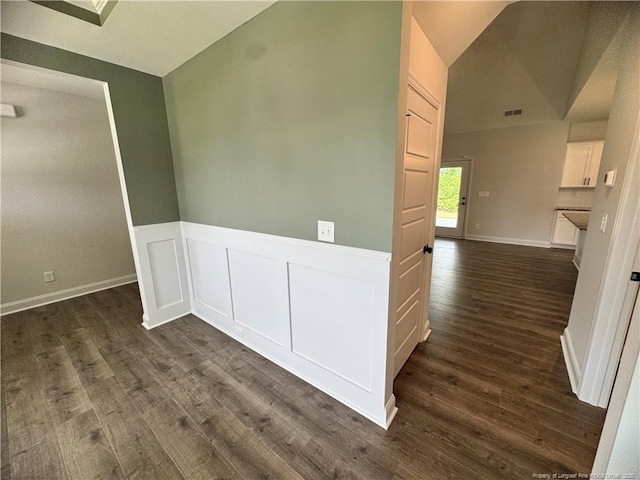 374 Whitestone Dr, Fayetteville, NC 28312 - empty room featuring dark wood finished floors, a wainscoted wall, and lofted ceiling