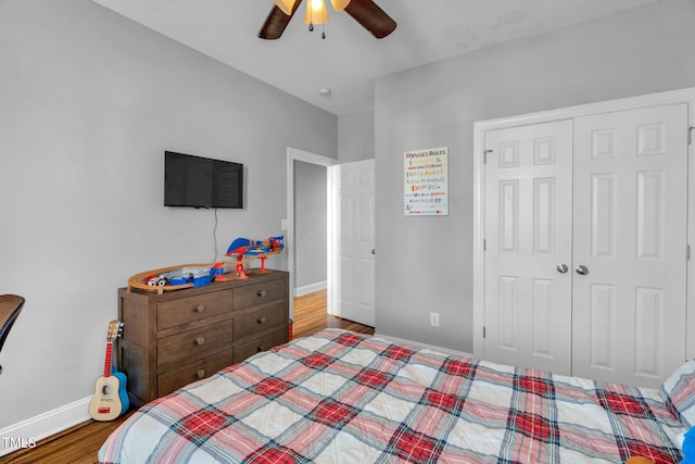 bedroom featuring a closet, a ceiling fan, wood finished floors, and baseboards