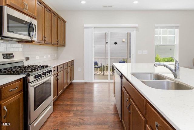 1018 Excite Ave, Morrisville, NC 27560 - kitchen with stainless steel appliances, dark wood-type flooring, backsplash, recessed lighting, and brown cabinets
