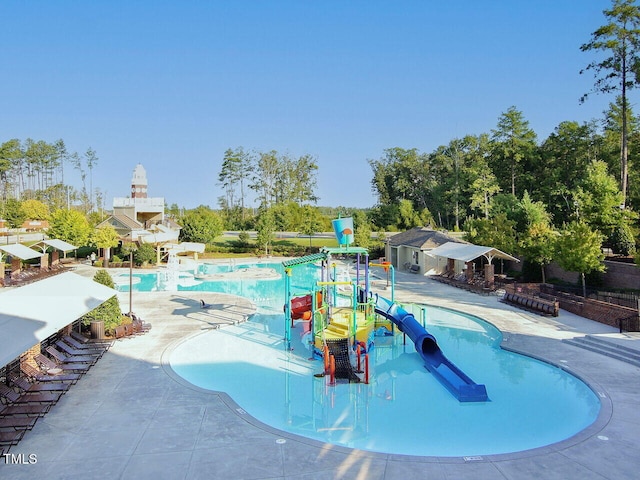 pool featuring a water slide, a patio area, and a water play area