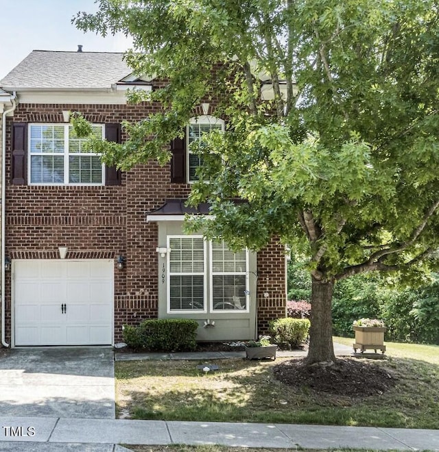 view of front of property featuring an attached garage, a shingled roof, brick siding, and concrete driveway