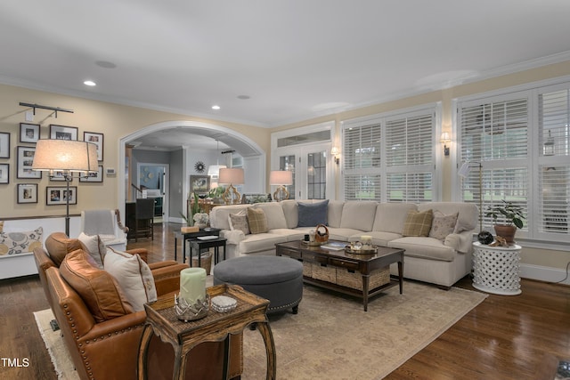 living room with arched walkways, dark wood finished floors, ornamental molding, and recessed lighting