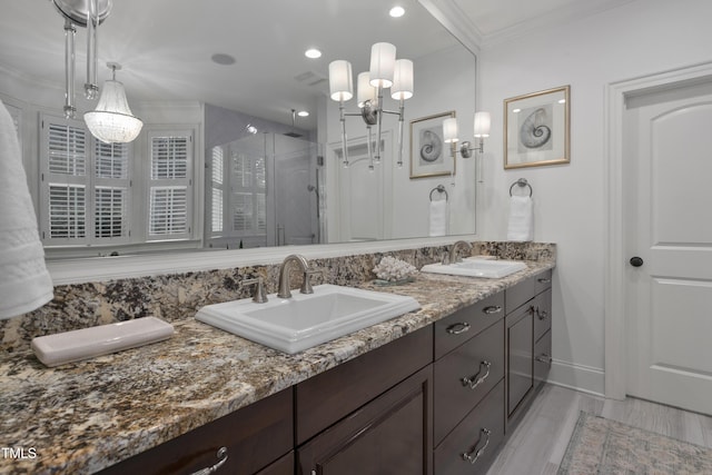 bathroom with a sink, a shower stall, recessed lighting, and double vanity