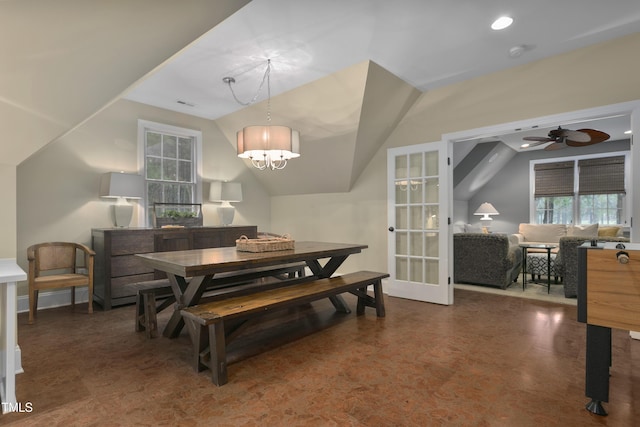 dining space featuring baseboards, vaulted ceiling, a healthy amount of sunlight, and ceiling fan with notable chandelier