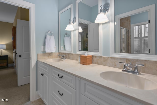 full bath with a sink, a stall shower, and double vanity